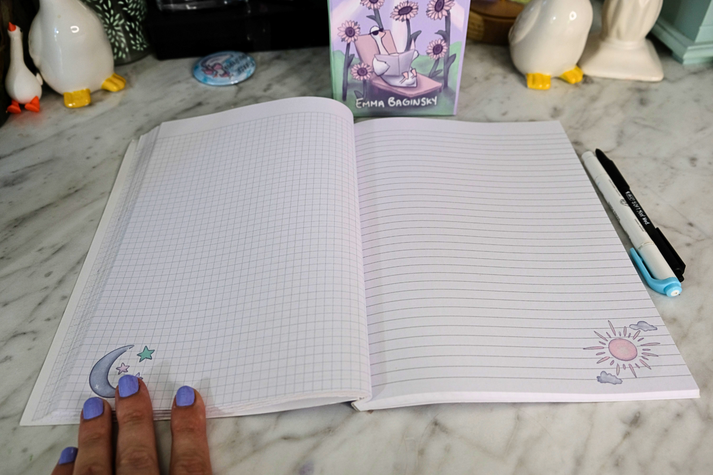 Open notebook with decorative pages on a marble surface