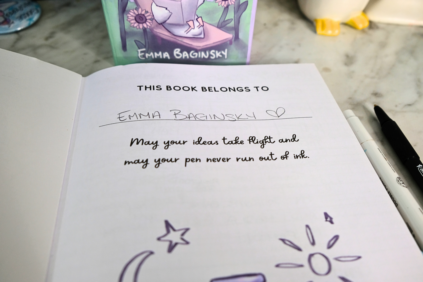 Book with personalized inscription and doodles on a desk