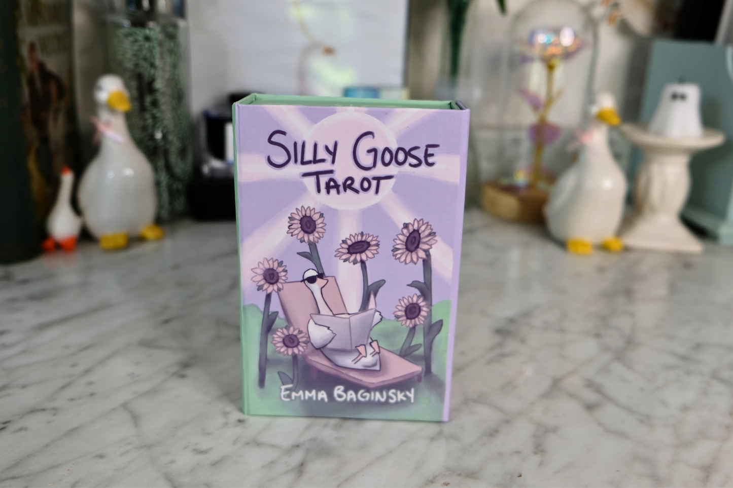 Silly Goose Tarot card box with illustrated goose and sunflowers on a marble surface.